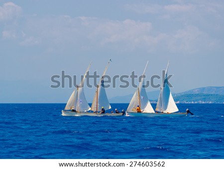 SPETSES, GREECE - JUN 22, 2014: Unidentified people on 2 Greek classic wooden sailing boats during a regatta in Spetses island in Greece on Jun 22, 2014