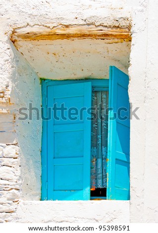 A wooden blue colored window of a Beautiful old traditional house in Chora the capital of Amorgos island in Greece