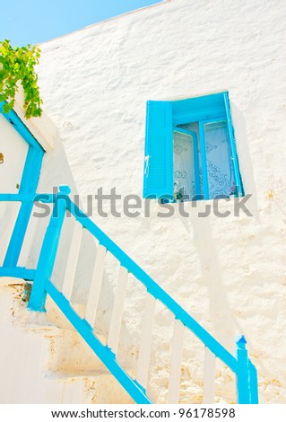 Beautiful old traditional house with wooden blue colored doors and windows and a stair in Chora the capital of Amorgos island in Greece