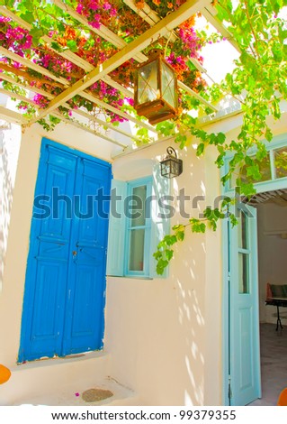 A beautiful traditional old house with pergola and blue colored doors and windows in Chora the capital of Amorgos island in Greece