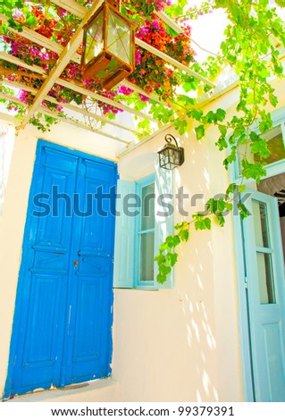 A beautiful traditional old house with pergola and blue colored doors and windows in Chora the capital of Amorgos island in Greece