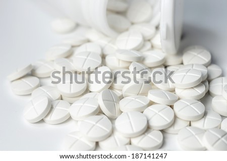 white pills out of pill bottle