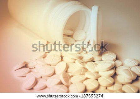 white pills out of pill bottle
