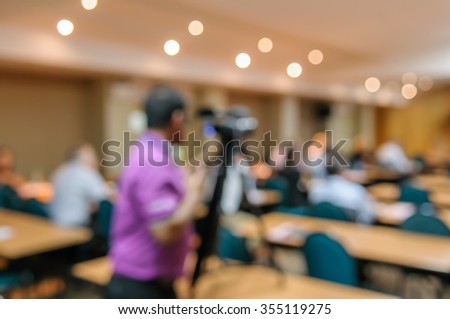 abstract blurred image of cameraman video camera recording in conference meeting