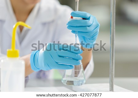 The woman who\'s the scientist is demonstrate the titration technique in the laboratory