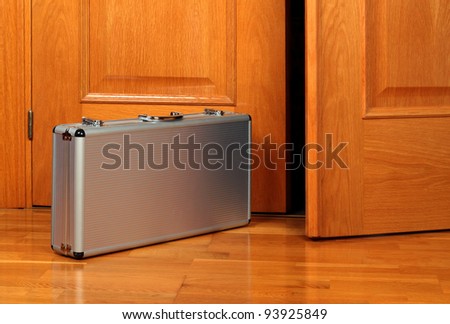 Briefcase on the oak parquet near the open oak door
