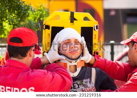 NINE, PORTUGAL - APRIL 12, 2014: Emergency crew immobilizes victim with a cervical collar in a stretcher during a simulated train accident