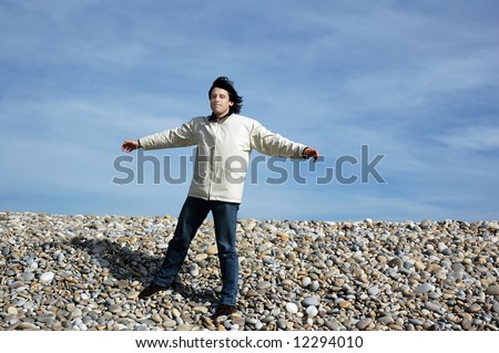 young man open arms at the beach
