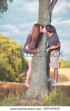 attractive young man and woman kissing outdoors