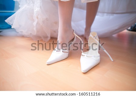 Bride fitting shoes on her wedding day