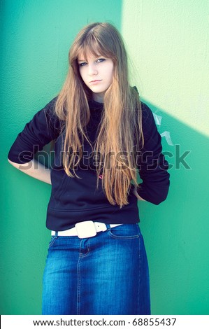 fashion vintage portrait of beautiful young woman posing over the green metal wall