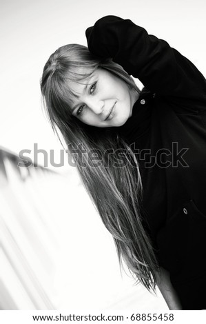 fashion portrait of beautiful young woman posing over the blurred metal wall