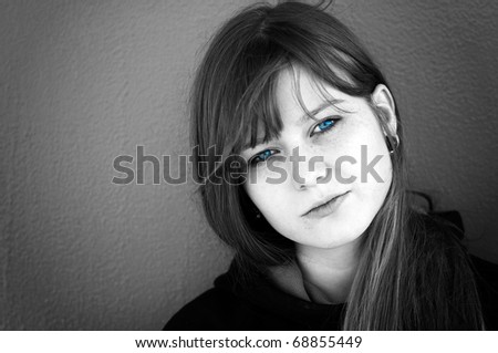fashion black and white portrait of beautiful young woman posing over the metal wall. eyes in color