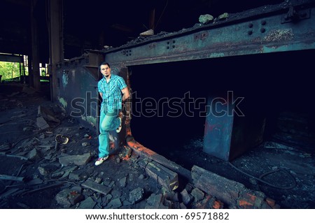 portrait of attractive young man posing in old factory