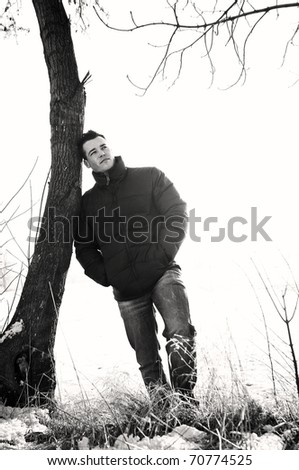 attractive young man posing in winter park. black & white
