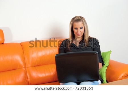 Beautiful woman sitting on the sofa with a laptop