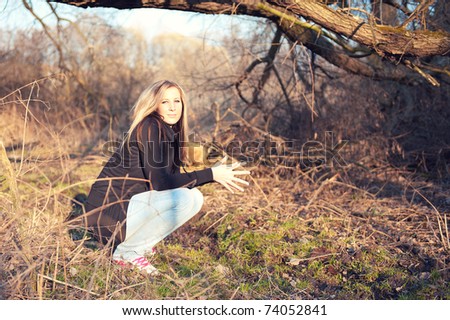 Portrait of young woman crouching at the park