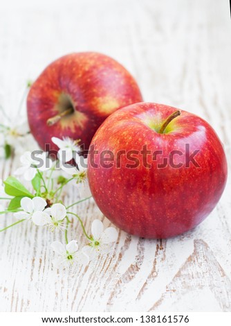 Two apples and spring blossom on a wooden background