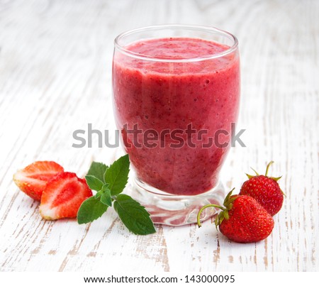 A Glass Of Strawberry Smoothie On A Wooden Background