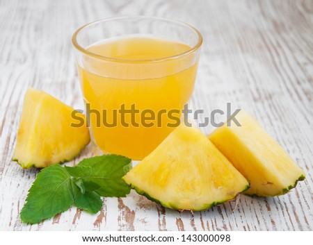 sliced pineapple with a glass of pineapple juice