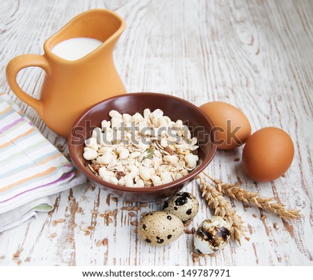 Muesli, wheat,  milk  and eggs on a wooden background