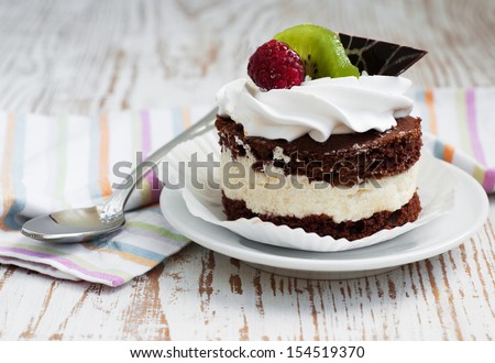 chocolate cake with raspberry and kiwi on a wooden background