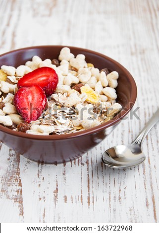 A bowl of cereal with fresh strawberries
