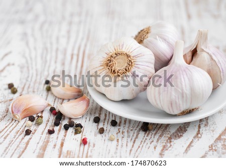 Garlic with peppercorns on a wooden background