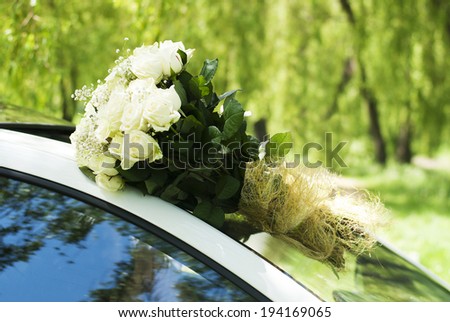 Big white roses  bouquet on white car