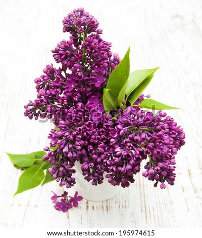 summer lilac flowers in vase on a wooden background