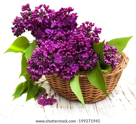 summer lilac flowers in basket on a wooden background