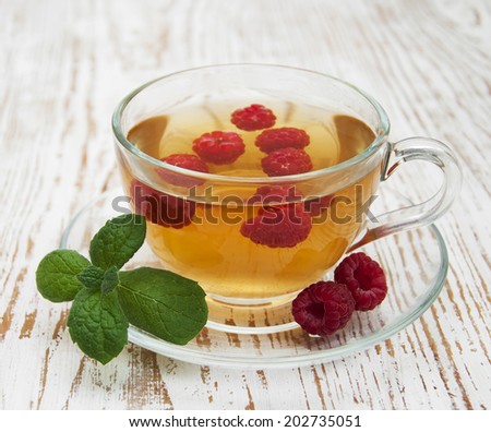Cup of tea with raspberry  and some fresh raspberries