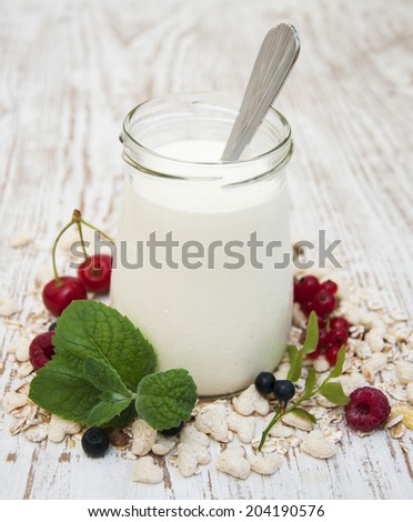 Yogurt and Cereals with fresh fruits on a wooden background