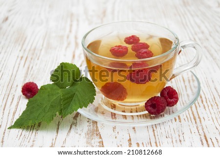 Ã?Â�Ã?Â¡up of tea with raspberry  and some fresh raspberries