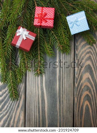 christmas trees with heap of gift boxes on a wooden background