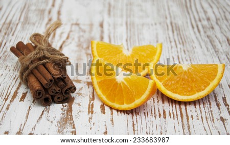Orange with cinnamon sticks on a wooden background