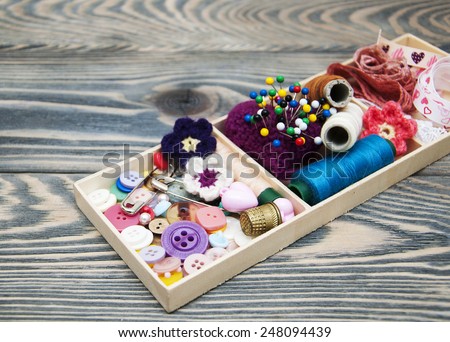 thread and material for handicrafts in box on a wooden background