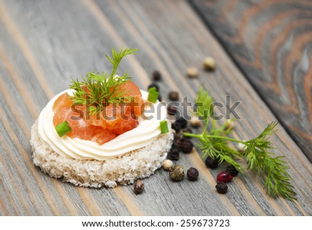 canape with salmon and dill on a wooden table
