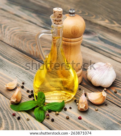 olive oil with fresh basil and garlic on a old wooden background