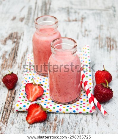 Strawberry fruit smoothies with fresh strawberries on a old wooden background