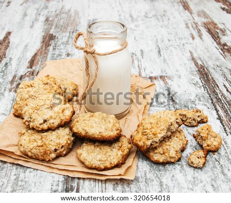 oatmeal cookies and  milk on a old wooden background