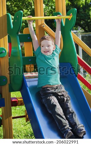 The cheerful child on a playground in the summer evening