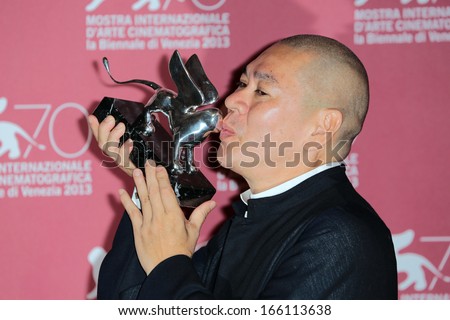 VENICE, ITALY - SEPTEMBER 07: Tsai Ming-liang poses with the Grand Jury Prize he received for his movie \'Jiaoyou\' during the 70th Venice Film Festival on September 07, 2013 in Venice, Italy