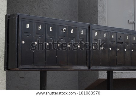 metallic mailbox array tidy infront of apartment houses