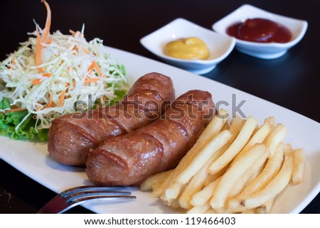 Sausages and french fries on white plate
