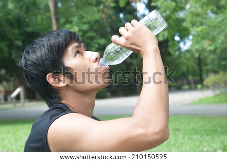 portrait of young man jogger drinking water from bottle