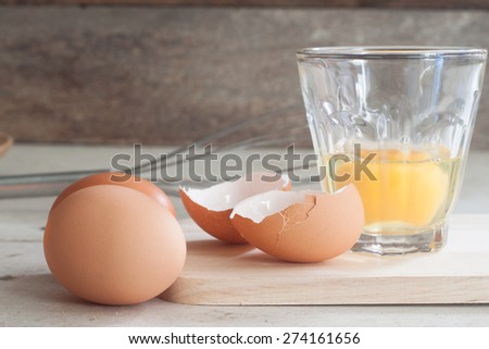 ingredients and tools to make a cake, eggs, bakery cups on wood table