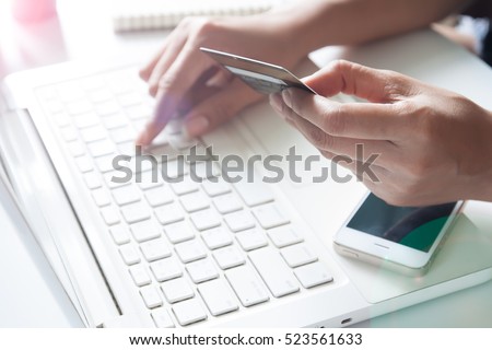 Hand holding dollar and using laptop. Online shopping