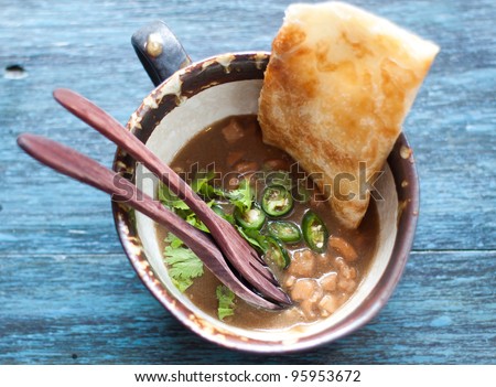 Chicken soup with chilly and crispy on blue wooden table