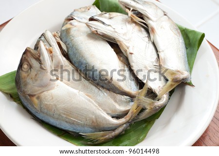 boiled mackerel on green banana leaf and white dish